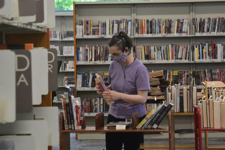 Library assistant Natalia Froberg shelves books in the popular holds section at the Bellingham Public Library in May 2021. The main floor of the library underwent a $2.5 million remodeling project that added comfortable chairs and more electrical plugs for mobile phones and laptop computers.