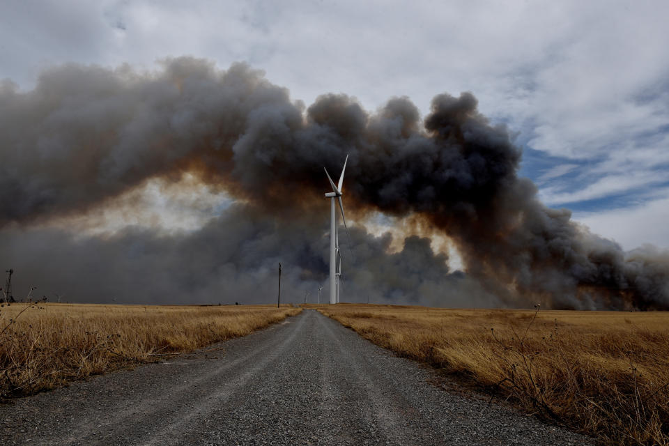 The Rhea fire burns in the distance behind a wind farm near Seiling, Oklahoma. (Photo: Nick Oxford / Reuters)