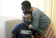 Julian Boyce, 14, gets a hug from his mother, Satrina Boyce, after he received his first Pfizer COVID-19 vaccination dose at NYC Health + Hospitals/Harlem, in New York, Thursday, May 13, 2021. New York Gov. Andrew Cuomo announced Wednesday that children between the ages of 12 and 15 can get vaccinated in New York effective immediately. (AP Photo/Richard Drew)