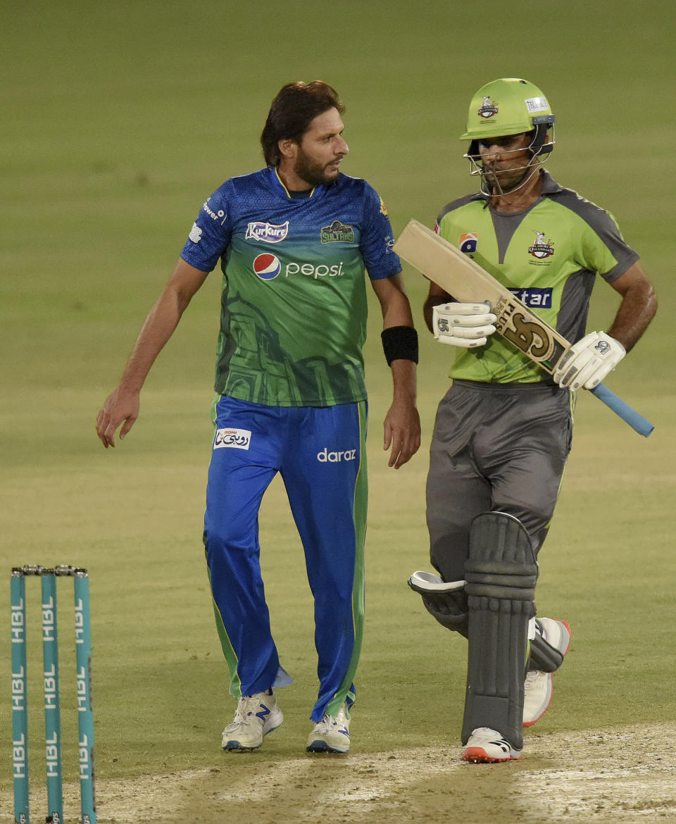 Multan Sultans spinner Shahid Afridi, left, chats with Lahore Qalandars batsman Fakhar Zaman during the second eliminator cricket match of Pakistan Super League T20 cup at National Stadium in Karachi, Pakistan, Sunday, Nov. 15, 2020. (AP Photo/Fareed Khan)