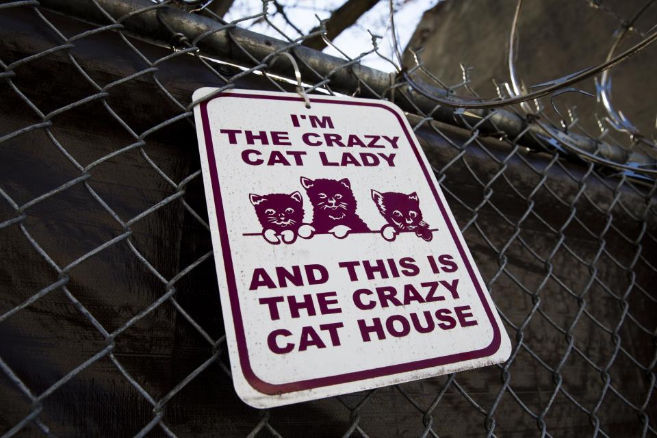 A sign is posted on fence at the location of where Members of the Pennsylvania Society for the Prevention of Cruelty to Animals remove cats from two connected row homes Wednesday, March 26, 2014, in Philadelphia. The Animal welfare authorities say they are working to remove about 260 cats and take them to the organization's north Philadelphia shelter, where veterinarians were waiting to examine them. (AP Photo/Matt Rourke)