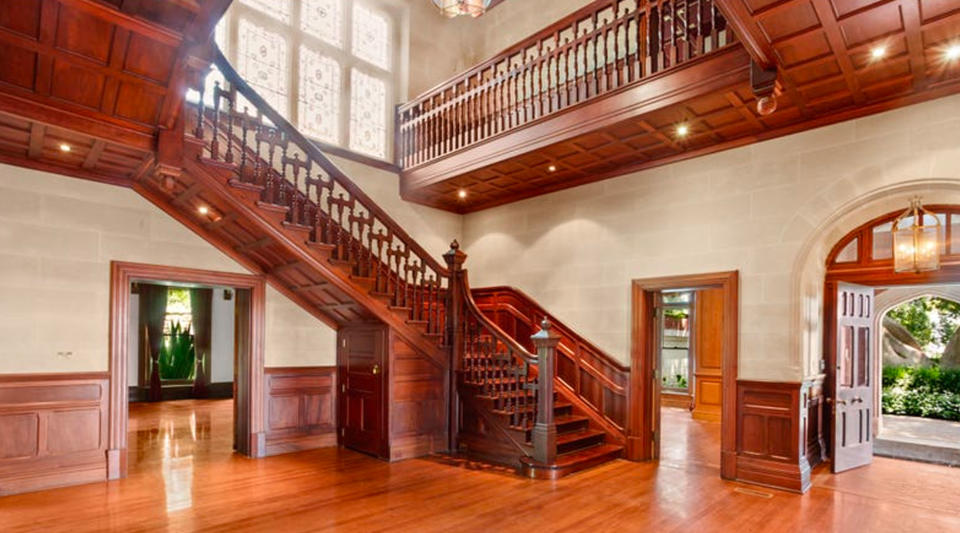 A grand entryway with timber stairs.