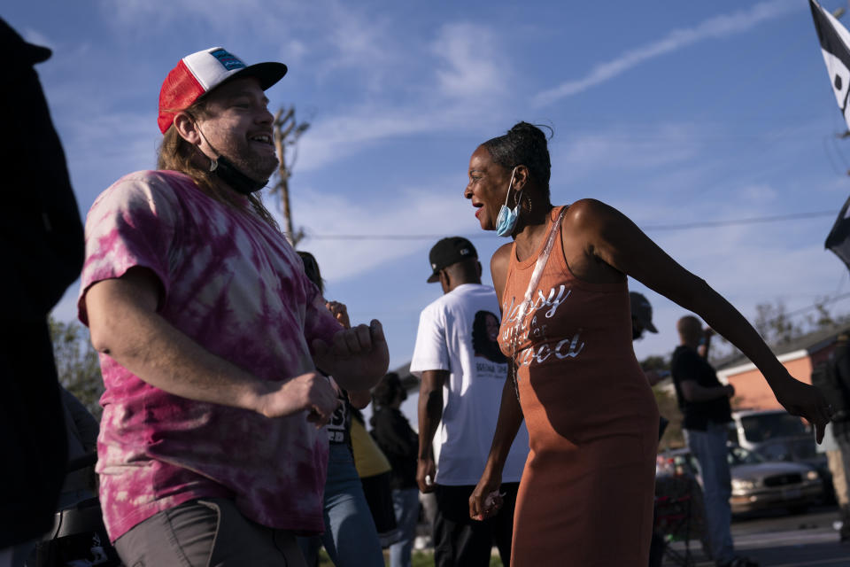 Sherri Burks, right, and Dominic Fawcett dance at the intersection of Florence and Normandie Avenues, Tuesday, April 20, 2021, in Los Angeles, after a guilty verdict was announced at the trial of former Minneapolis police Officer Derek Chauvin for the 2020 death of George Floyd. (AP Photo/Jae C. Hong)