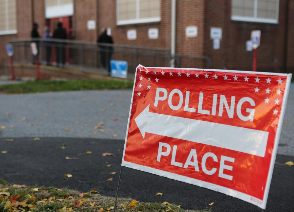 A handful of people wait outside of a polling site at Harlan Elementary School in Wilmington to vote on Tuesday.