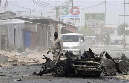 A man looks at the scene of an explosion near the entrance of the airport in Somalia's capital Mogadishu February 13, 2014. REUTERS/Omar Faruk