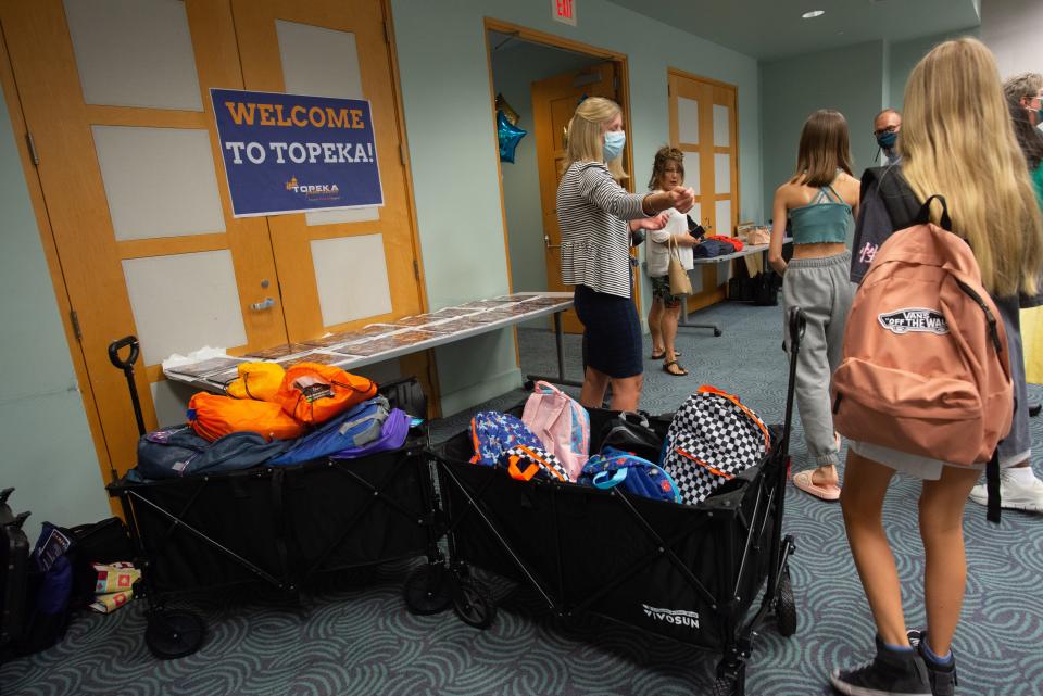 Ukrainian children, soon-to-be students in Topeka USD 501, pick from bags of donated school supplies and materials.