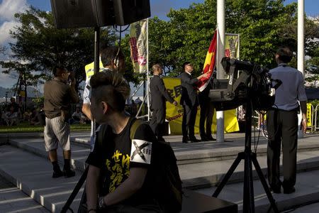 A pro-democracy protester (2nd L) reacts as flagbearers lower a Chinese national flag during a demonstration outside Legislative Council in Hong Kong, China June 17, 2015. REUTERS/Tyrone Siu