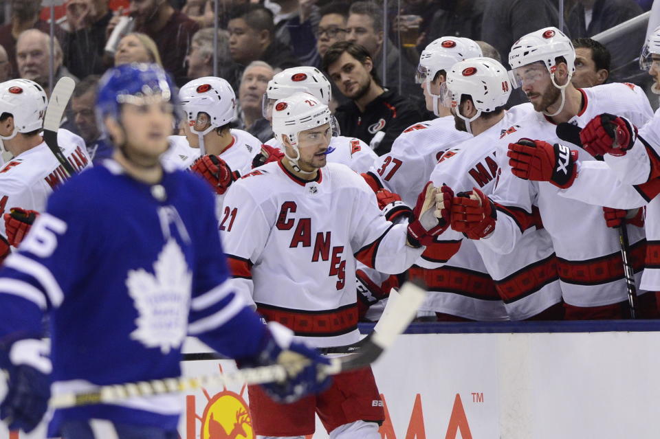 Carolina Hurricanes right wing Nino Niederreiter (21) celebrates after scoring against Toronto Maple Leafs goaltender Frederik Andersen with teammates at his bench during second-period NHL hockey game action in Toronto, Saturday, Feb. 22, 2020. (Frank Gunn/The Canadian Press via AP)