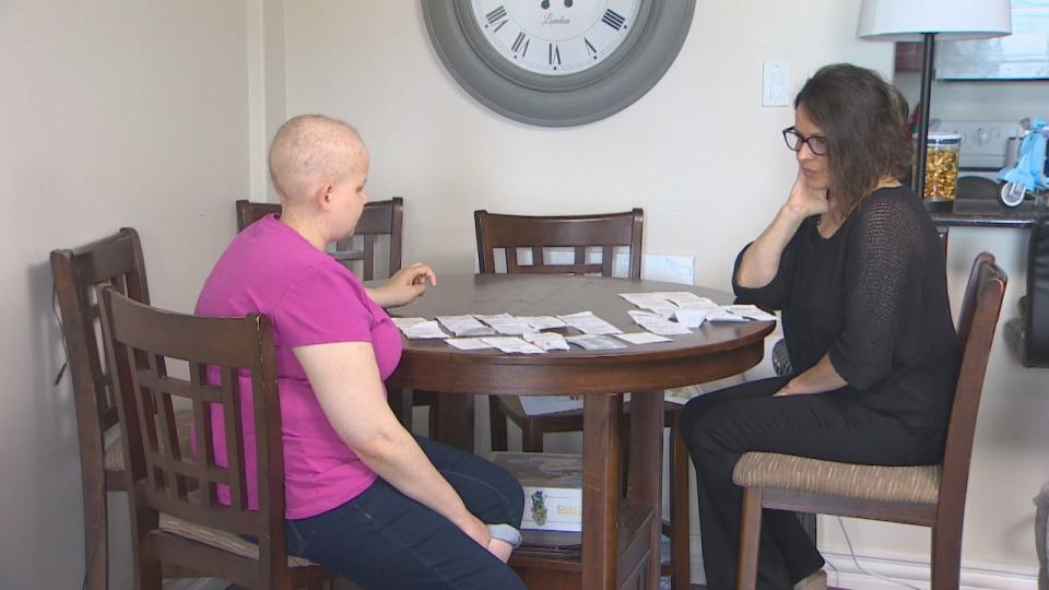 Emma and her mother Tracie look at all the gift cards she was tricked into purchasing by phone scam. 