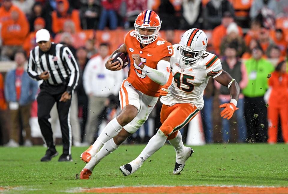 Clemson quarterback D.J. Uiagalelei (5) runs by Miami defensive lineman Mitchell Agude (45) during the third quarter at Memorial Stadium in Clemson, South Carolina Saturday, Nov. 19, 2022.   