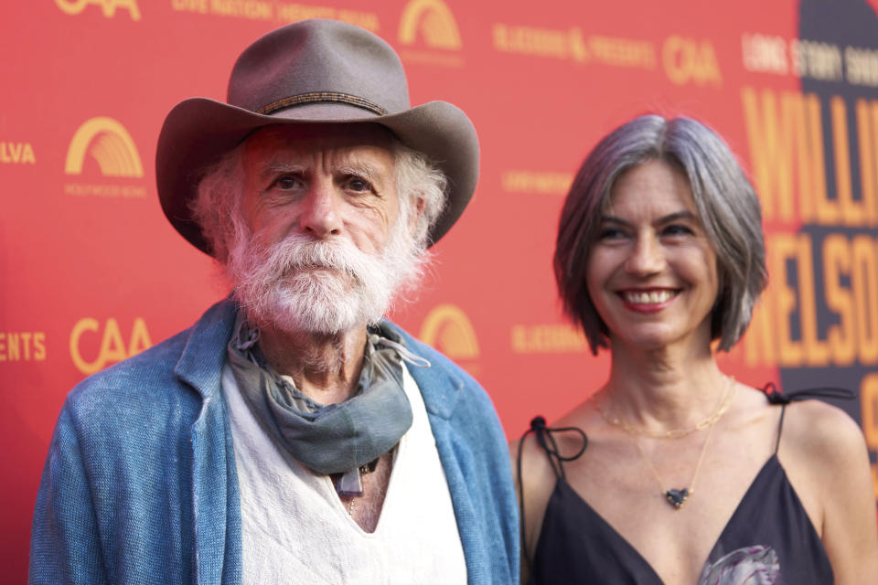 Bob Weir, left, and Natascha Munter arrive at Willie Nelson 90, celebrating the singer's 90th birthday on Saturday, April 29, 2023, at the Hollywood Bowl in Los Angeles. (Photo by Allison Dinner/Invision/AP)