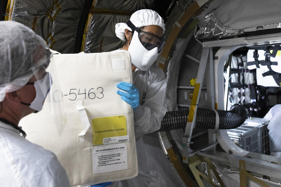 This photograph was taken inside the mobile clean room attached to Northrop Grumman's Antares rocket as it rests atop Pad 0A at NASA's Wallops Flight Facility in Wallops, Island, Va. on Sept. 28, 2020. Mechanical Technician Stephen Busch, left, and Jennie Wang, Lead Integration and Test Mechanical Engineer for Northrop Grumman, load the cargo bag containing the Space Camera through the hatch of the Cygnus Pressurized Cargo Module. The vehicle successfully docked with the International Space Station on October 5.<span class="copyright">Philip Andrews—for TIME</span>