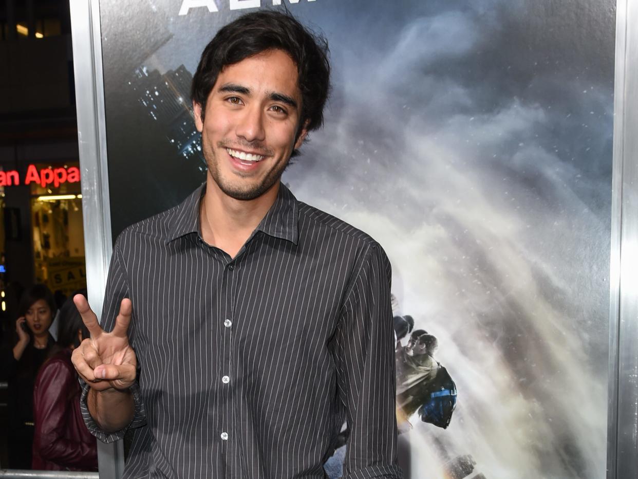 zach king holding up a peace sign while smiling