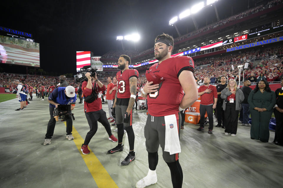 Tampa Bay Buccaneers wide receiver Mike Evans (13) and quarterback Baker Mayfield, right, stand for the national anthem before an NFL wild-card playoff football game against the Philadelphia Eagles, Monday, Jan. 15, 2024, in Tampa, Fla. (AP Photo/Phelan M. Ebenhack)