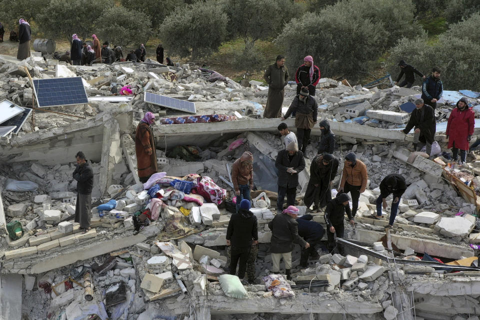 Civil defense workers and residents search through the rubble of collapsed buildings in the town of Harem near the Turkish border, Idlib province, Syria, Monday, Feb. 6, 2023. A powerful earthquake has caused significant damage in southeast Turkey and Syria and many casualties are feared. Damage was reported across several Turkish provinces, and rescue teams were being sent from around the country. (AP Photo/Ghaith Alsayed)