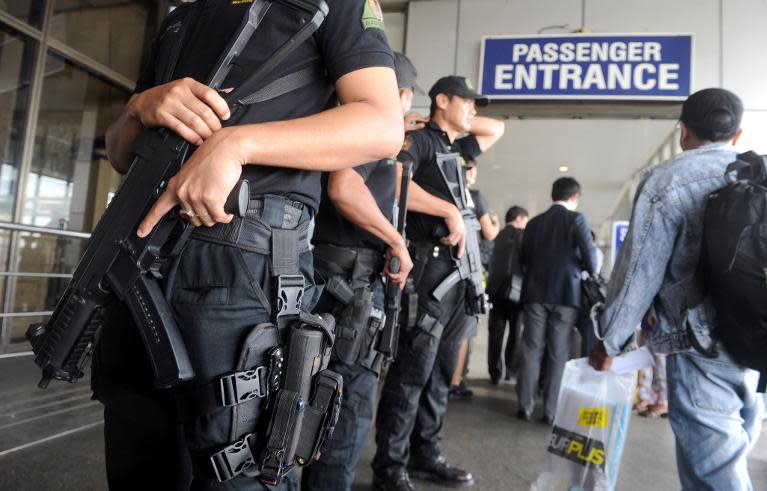 Heavily armed Philippine anti-terrorist police (L) patrol around Manila's International Airport terminal on March 11, 2014