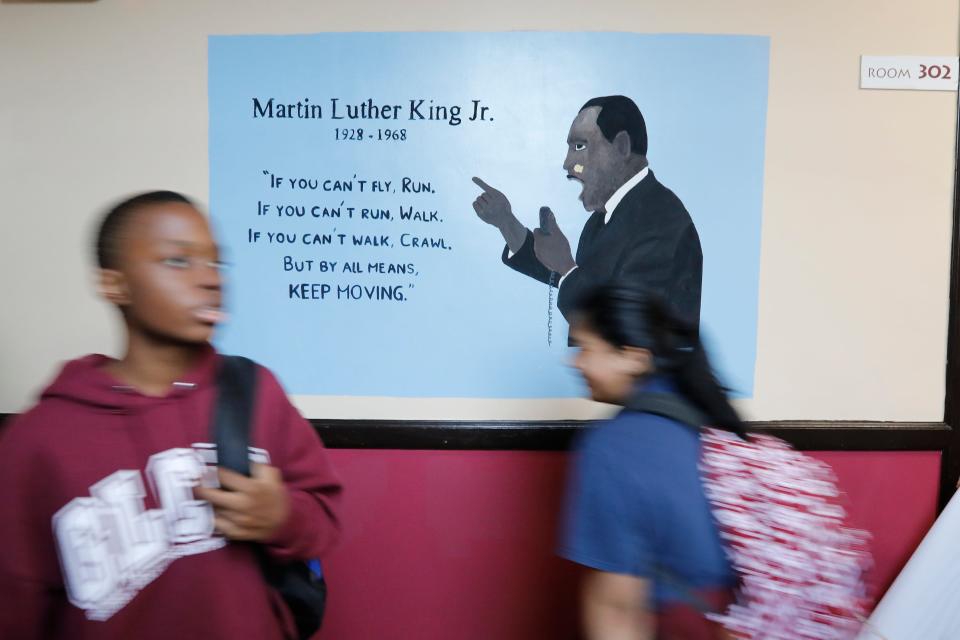 Students walk past a mural celebrating Martin Luther King at the Global Learning Charter Public School in New Bedford which is celebrating its 20th anniversary.