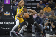 Golden State Warriors guard Jordan Poole, left, guards Sacramento Kings guard De'Aaron Fox during the first quarter of an NBA basketball game in Sacramento, Calif., Sunday, Oct. 24, 2021. (AP Photo/Randall Benton)