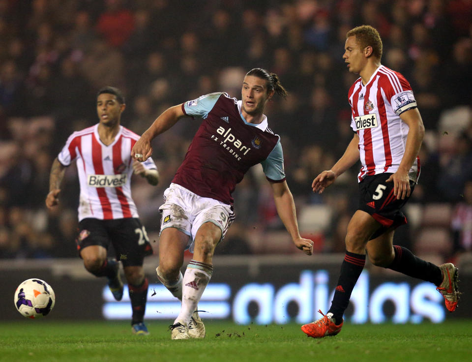 West Ham United's Andy Carroll, left, vies for the ball with Sunderland's captain Wes Brown, right, during their English Premier League soccer match at the Stadium of Light, Sunderland, England, Monday, March 31, 2014. (AP Photo/Scott Heppell)