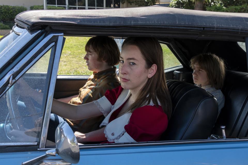 Cooper Hoffman and Alana Haim ride in a car together