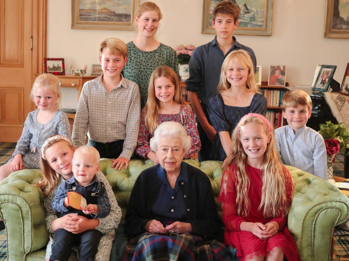 In this photo provided by Kensington Palace last year, Britain's Queen Elizabeth II poses for a photo in Balmoral, Scotland, with some of her grandchildren and great grandchildren in 2022. Last week,  Getty Images added an editor's note to the photo, warning that it was 'digitally enhanced at the source.' (Princess of Wales/Kensington Palace/The Associated Press - image credit)