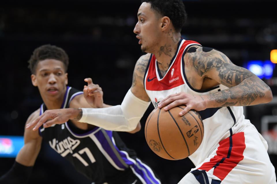 El alero de los Wizards de Washington Kyle Kuzma avanza hacia la canasta frente al alero de los Kings de Sacramento Kessler Edwards en el encuentro de la NBA del jueves 21 de marzo del 2024. (AP Foto/John McDonnell)