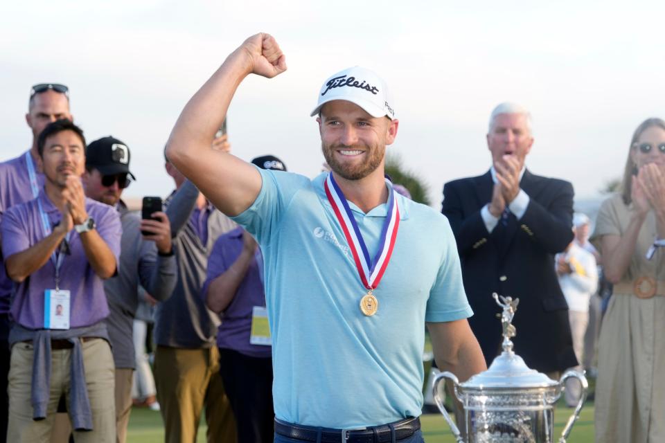 Wyndham Clark celebrates with the championship trophy after winning the U.S. Open.