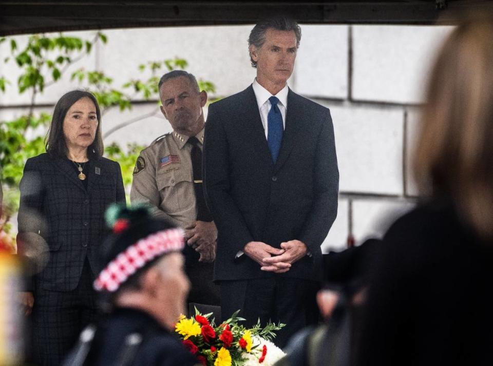 Lt. Gov. Eleni Kounalakis, Riverside County Sheriff Chad Bianco and Gov. Gavin Newsom stand Monday during the playing of bagpipes and drums during the California Peace Officers’ Memorial Ceremony at the state Capitol.