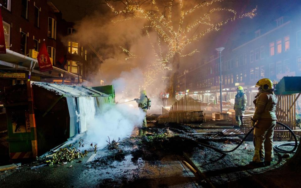Firefighters work to extinguish a fire on the Groene Hilledijk in Rotterdam after a second wave of riots in the Netherlands following the introduction of a coronavirus curfew over the weekend. -  Marco de Swart / ANP / AFP
