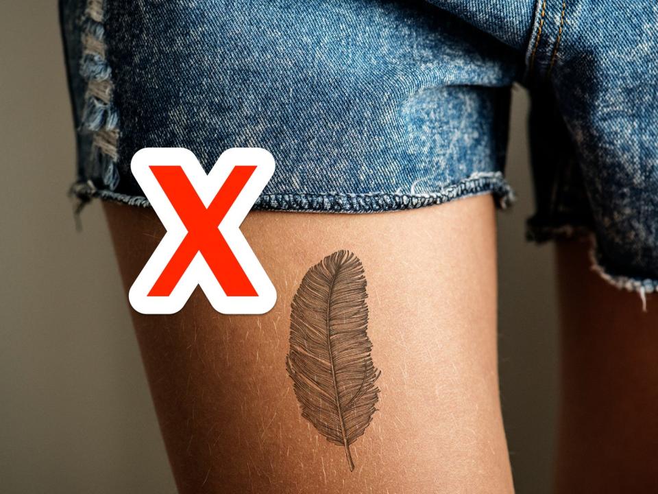 red x next to a feather tattoo on someone's leg