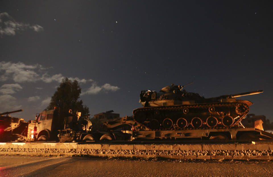 Turkish military convoy drives in Idlib province, Syria, Friday, Feb. 7, 2020. Several Turkish armored vehicles and tanks entered rebel-controlled northwestern Syria early on Friday, the latest reinforcements sent in by Ankara amid a Syrian government offensive that this week brought the two countries' troops into a rare direct confrontation. (AP Photo/Ghaith Alsayed)