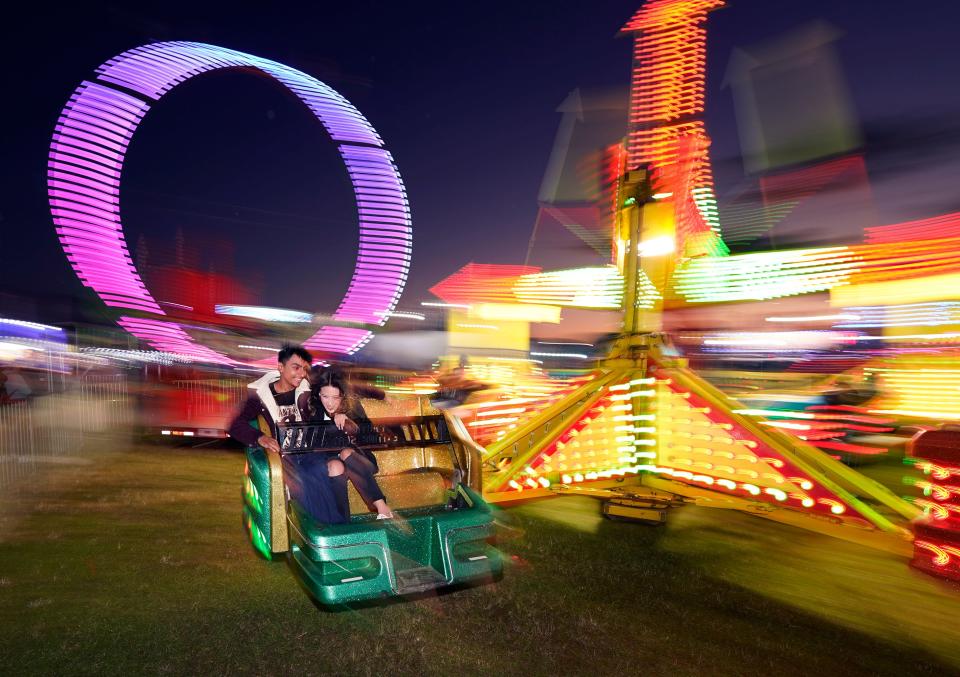 Visitors to the Volusia County Fair take a spin on one of the many midway rides during opening night, Thursday, Nov. 2, 2023, at the fairgrounds in DeLand.