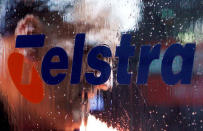 FILE PHOTO: A worker cleans up a Telstra public phone in central Sydney February 11, 2010. REUTERS/Daniel Munoz/File Photo