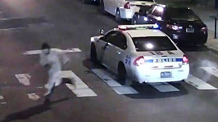 A still image from surveillance video shows a gunman (L) running away from a Philadelphia Police vehicle in which Officer Jesse Hartnett was shot in Philadelphia, Pennsylvania this Philadelphia Police Department image released on January 8, 2016. REUTERS/Philadelphia Police Department/Handout