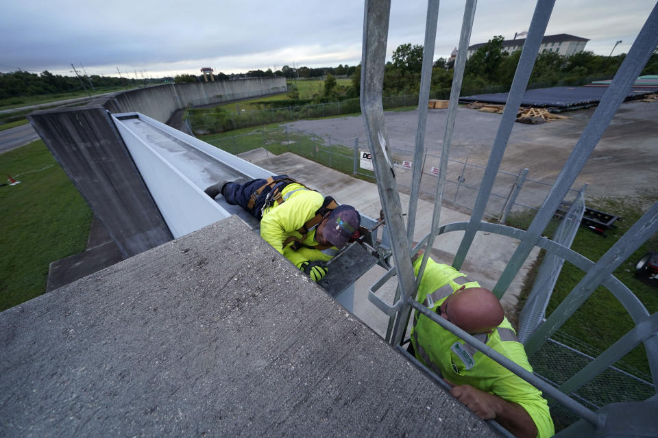 Workers for the Southeast Louisiana Flood Protection Authority - West, close floodgates in Harvey, La., just outside New Orleans, Monday, Aug. 24, 2020, in advance of Tropical Storm Marco, expected to come near the Southern Louisiana coast. (AP Photo/Gerald Herbert)