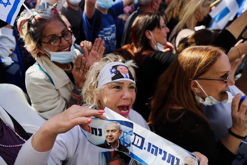 A supporter of Israeli Prime Minister Benjamin Netanyahu, wearing a headband with an image of Netanyahu, shouts slogans during a rally as Netanyahu's corruption trial resumes, near Jerusalem's District Court