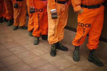 Prison inmates wearing firefighting boots line up for breakfast at Oak Glen Conservation Fire Camp #35 in Yucaipa, California November 6, 2014. REUTERS/Lucy Nicholson