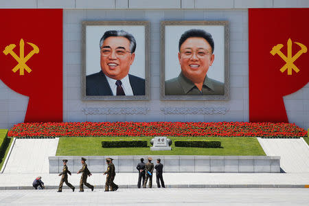 People stand in front of pictures of former North Korean leaders Kim Il Sung (L) and Kim Jong Il at the main Kim Il Sung square in central Pyongyang, North Korea, as the country holds the Workers' Party of Korea (WPK) Congress May 7, 2016. REUTERS/Damir Sagolj