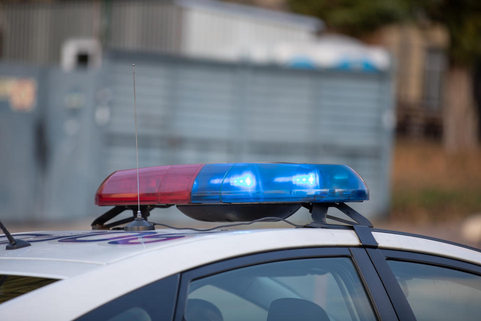 Flashing indicators on a roof of the police car at the day.