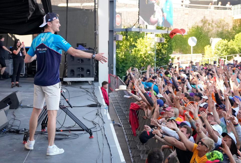 Williams Racing driver Logan Sargeant throws hats to fans at Friday's Driver Engagement event at Circuit of the Americas. Sargeant, an American driver who's on a one-year contract, is hoping to get a boost from racing at COTA.