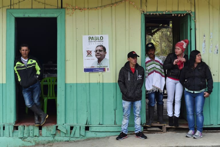 People look on as senate candidate Pablo Catatumbo and deputy candidate Marcos Calarca, both from the Common Alternative Revolutionary Force (FARC) political party, campaign in Santa Lucia, Valle del Cauca Department, Colombia, on February 25, 2018