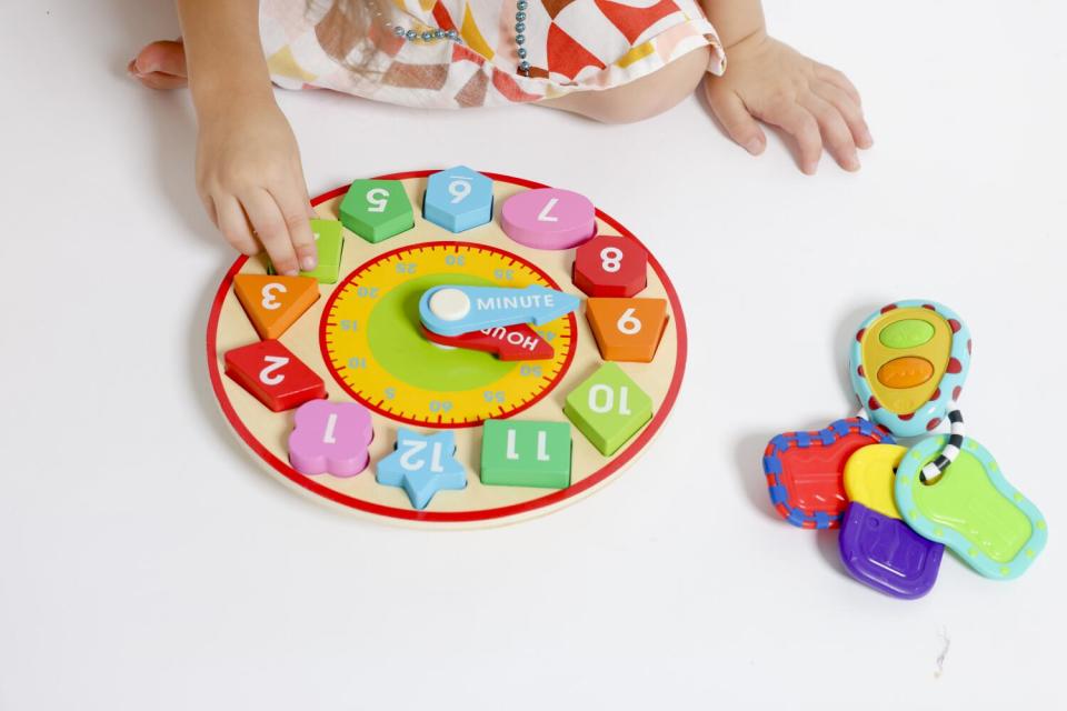 River Atchison plays with wooden toys at home