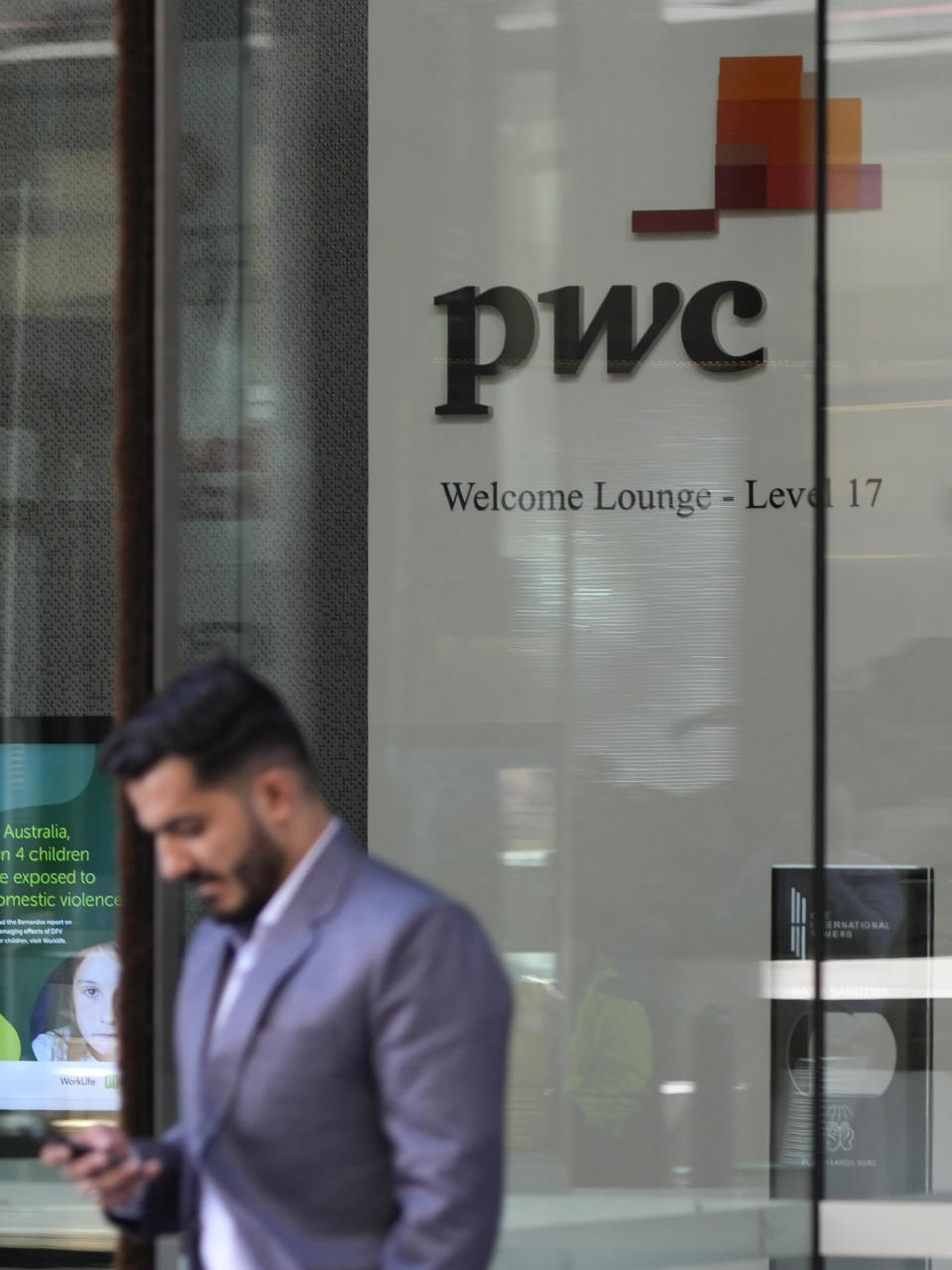 A man walks out of the offices of PricewaterhouseCoopers (PwC) in Sydney, Monday, May 29, 2023. The Australian branch of the PwC consultancy network announced it had ordered nine partners to take leave as an inquiry examines the leaking of confidential Australian tax avoidance policy changes to multinational corporate clients who could financially benefit from the information. (AP Photo/Rick Rycroft)