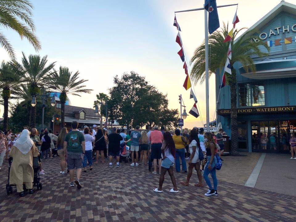 Crowds gather to watch the Amphicars leave the Boathouse restaurant at Disney Springs.