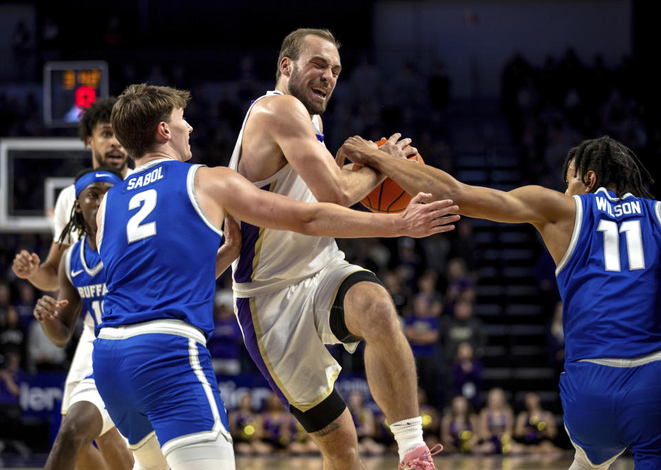 James Madison guard Noah Freidel, center, gets hung up between Buffalo guards Ryan Sabol (2) and Bryson Wilson (11) during the first half of an NCAA college basketball game in Harrisonburg, Va., Wednesday, Nov. 29, 2023. (Daniel Lin/Daily News-Record via AP)