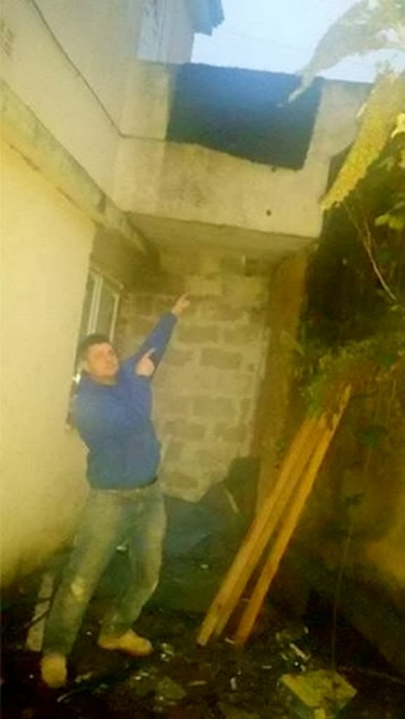 Chris Hepper points to where the student fell through his garage (Picture: SWNS)