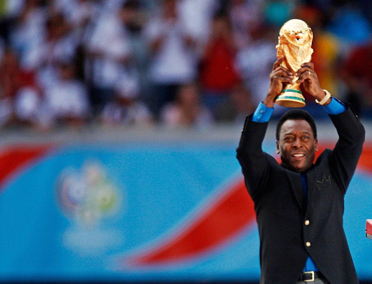 Brazilian soccer legend and member of the 1958, 1962 and 1970 World Cup-winning Brazilian soccer teams Pele holds the World Cup trophy during the World Cup 2006 opening ceremony in Munich June 9, 2006.  FIFA RESTRICTION - NO MOBILE USE    (GERMANY)     REUTERS/Dylan Martinez