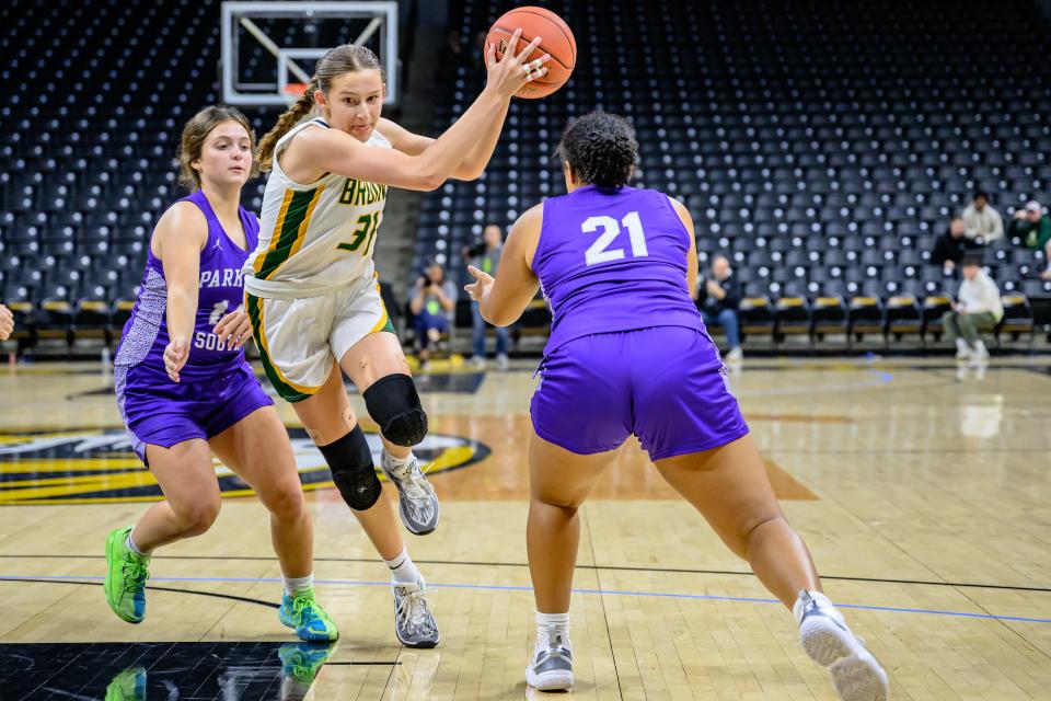 Rock Bridge's Mari Miller (31) drives to middle between Park Hill South's Sarah Listrom (14) & Joniyah Turner (21) during the Norm Stewart Classic at Mizzou Arena on Dec. 9, 2023, in Columbia, Mo.