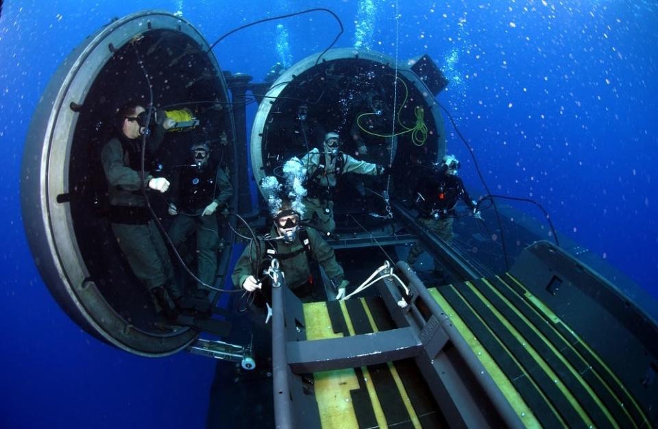 Navy divers and special operators perform SEAL delivery vehicle operations on a guided-missile submarine