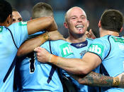 Beau Scott embraced by his teammates after scoring NSW's second try